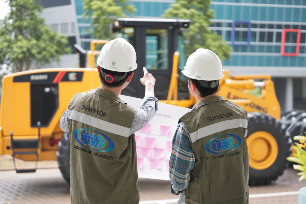 Surveyors beside construction machinery